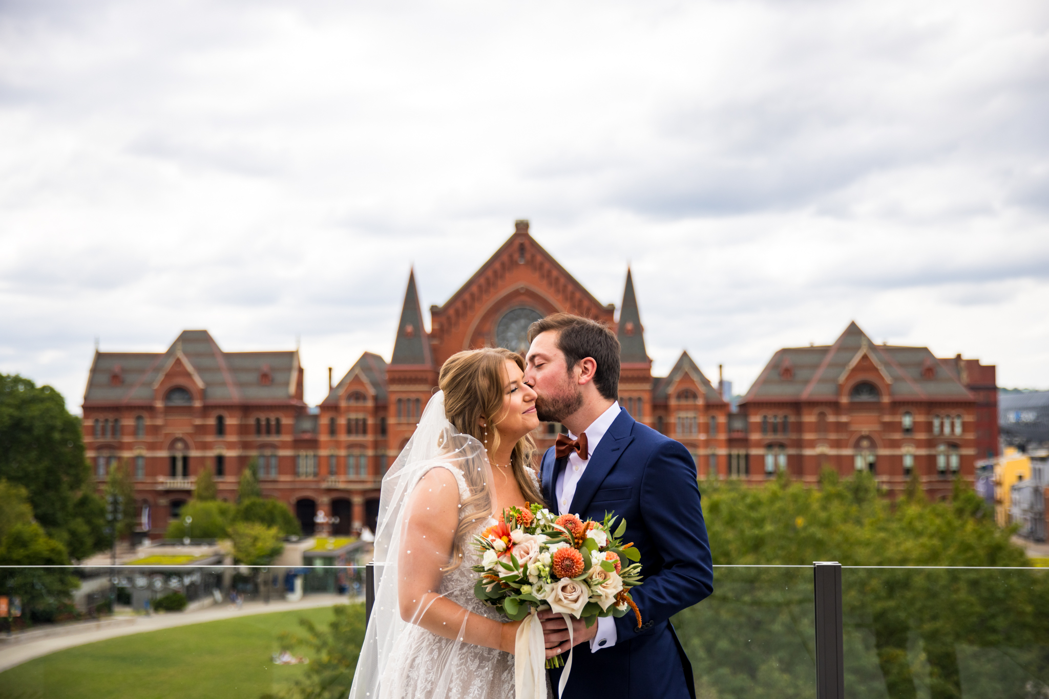 Bride and groom embrace in front of Cincinnati Music Hall